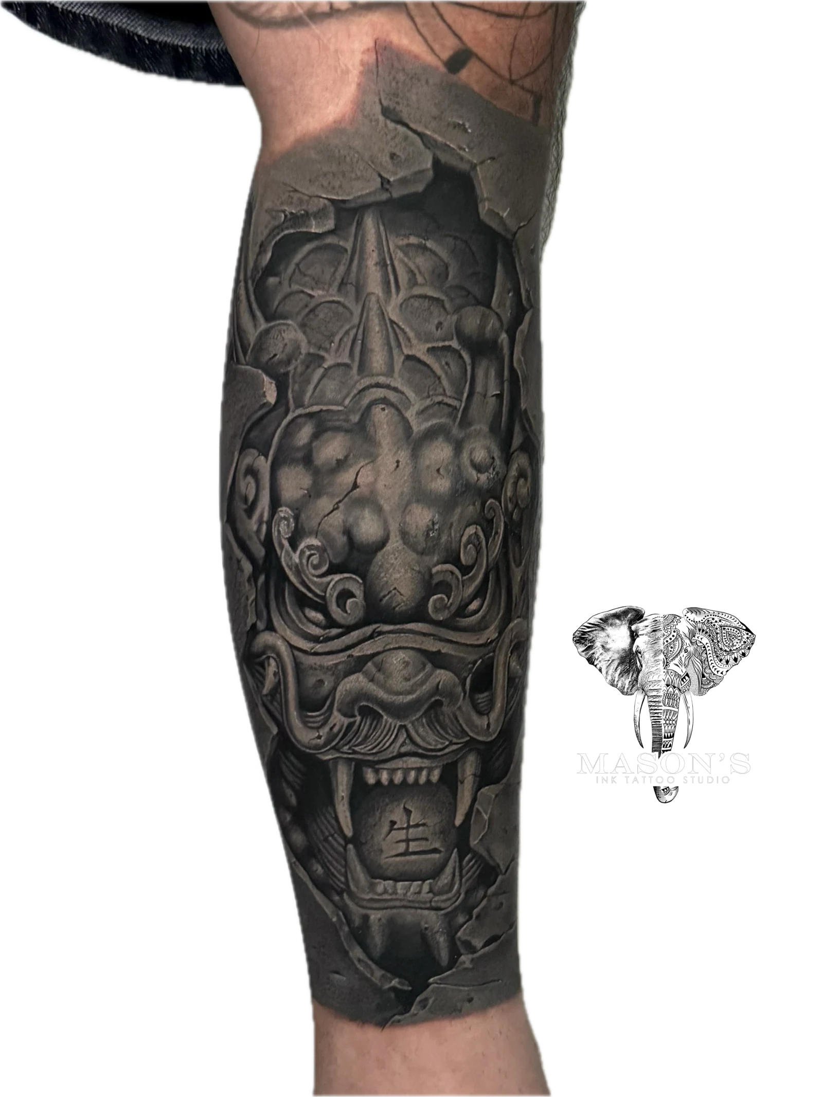 Black Work Japanese Tattoo Design: a detailed ornamental mask tattoo on the forearm