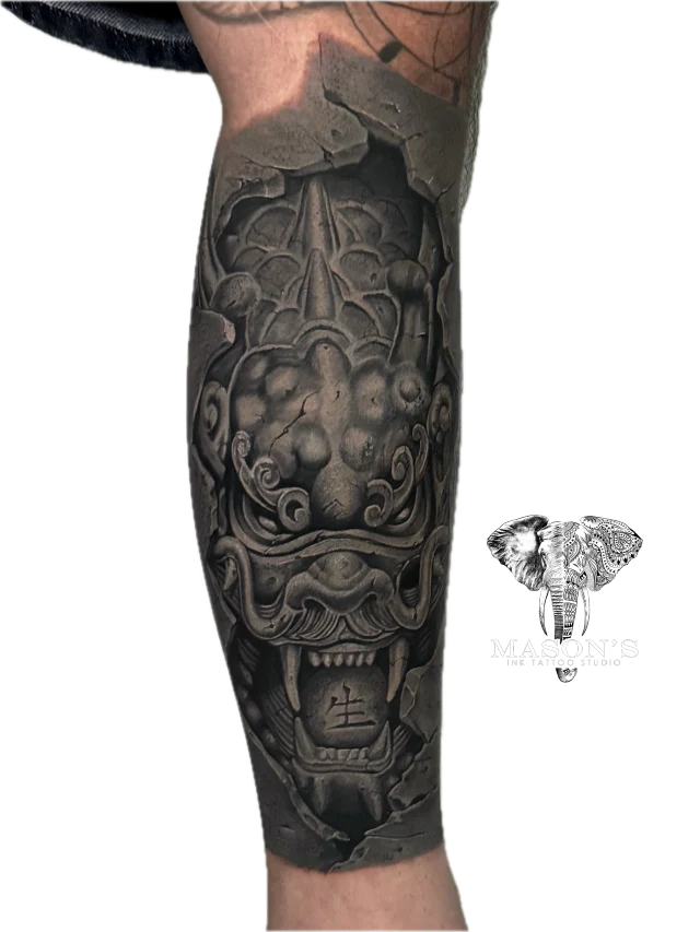 Black Work Japanese Tattoo Design: a detailed ornamental mask tattoo on the forearm