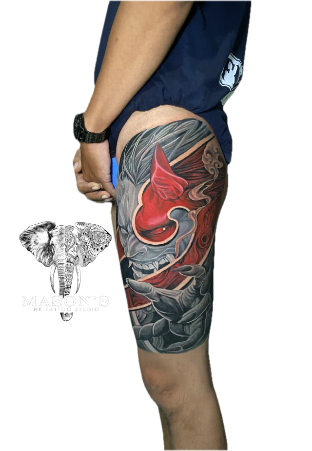 Colored Japanese Tattoo Design: a large thigh tattoo of a red and grey mythological mask with waves