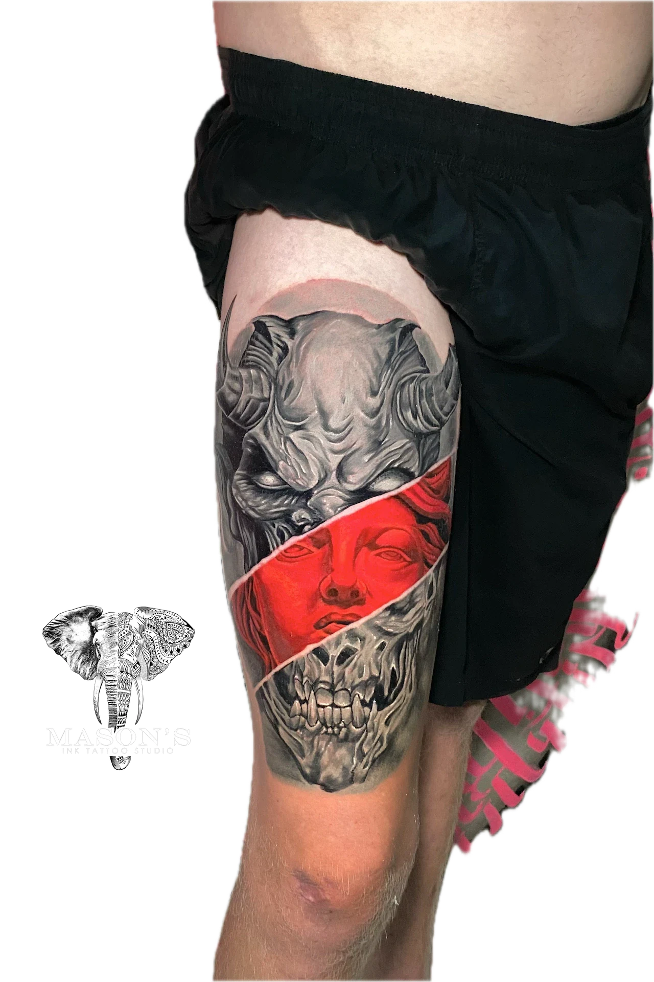 Black and Grey Japanese Demon Tattoo Design: a large thigh tattoo of a skull with a red face mask