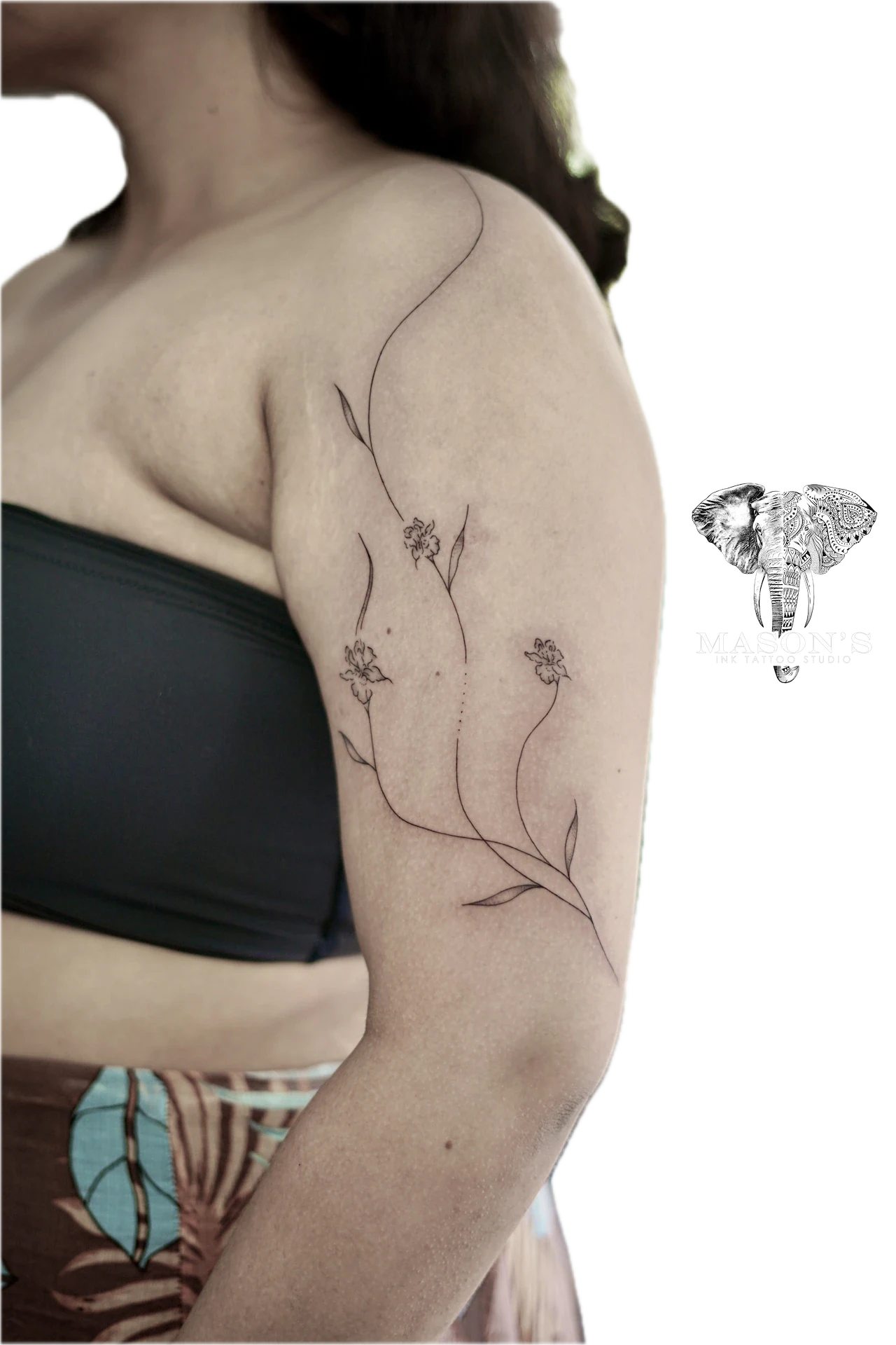 Floral Fine Line Tattoo Design: a delicate vine with flowers on the upper arm