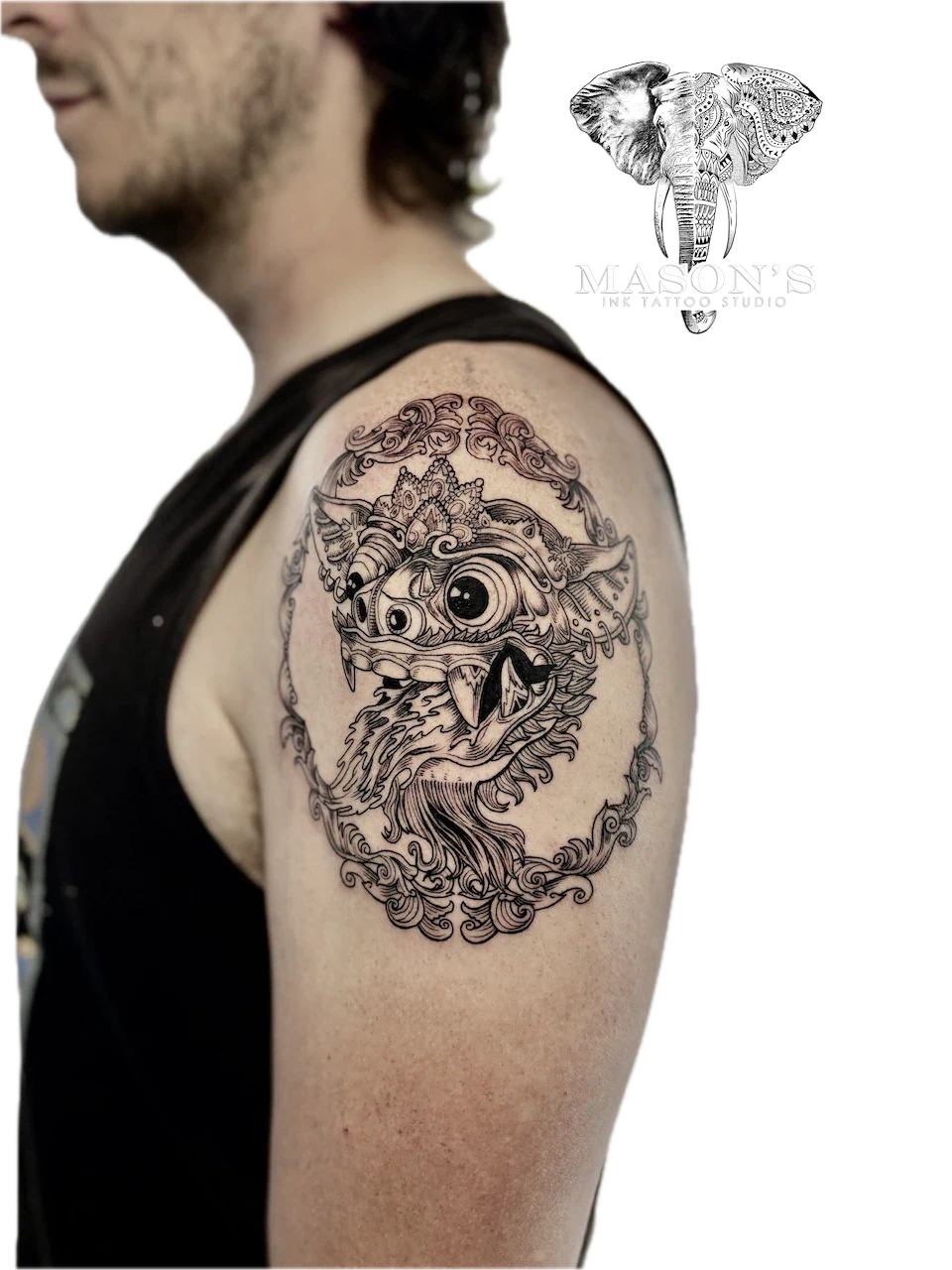 Barong Tattoo Design: a large ornate tattoo of an eye and bird on an upper arm