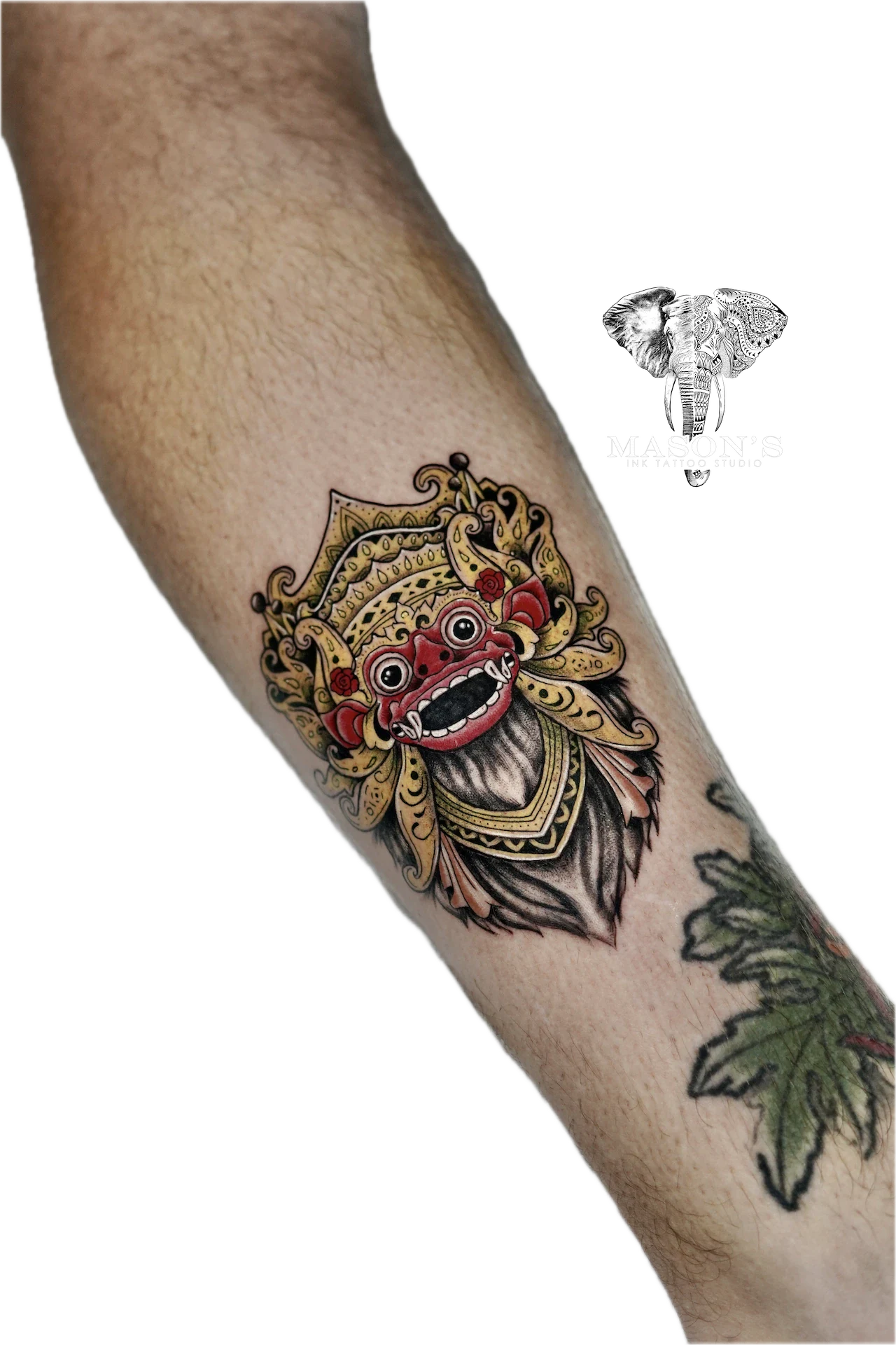 Balinese Barong Tattoo Design: a colorful ornate mask with intricate details on a forearm