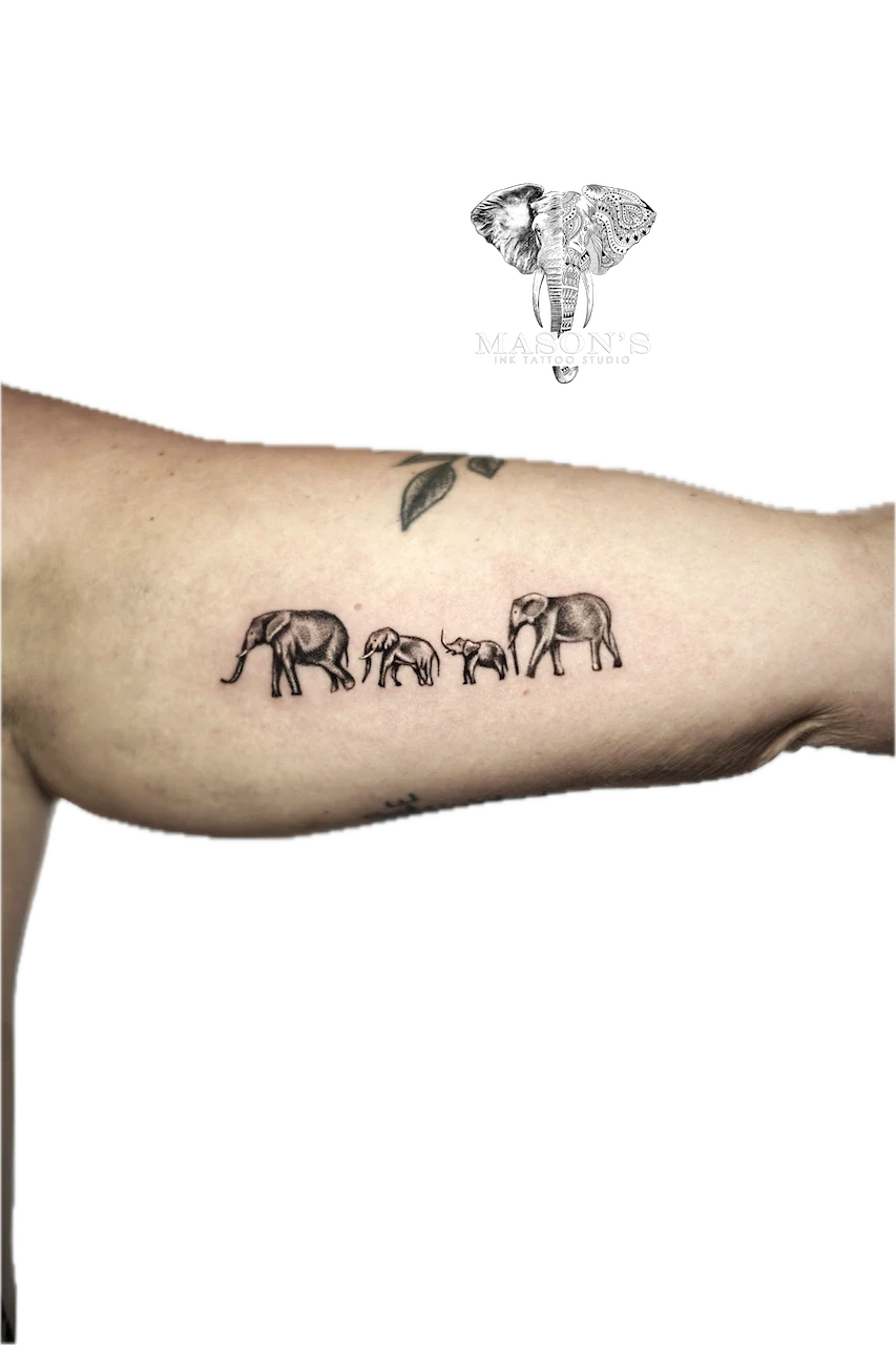 Black and Grey Elephant Tattoo Design: Four elephants walking in a line with a leaf above