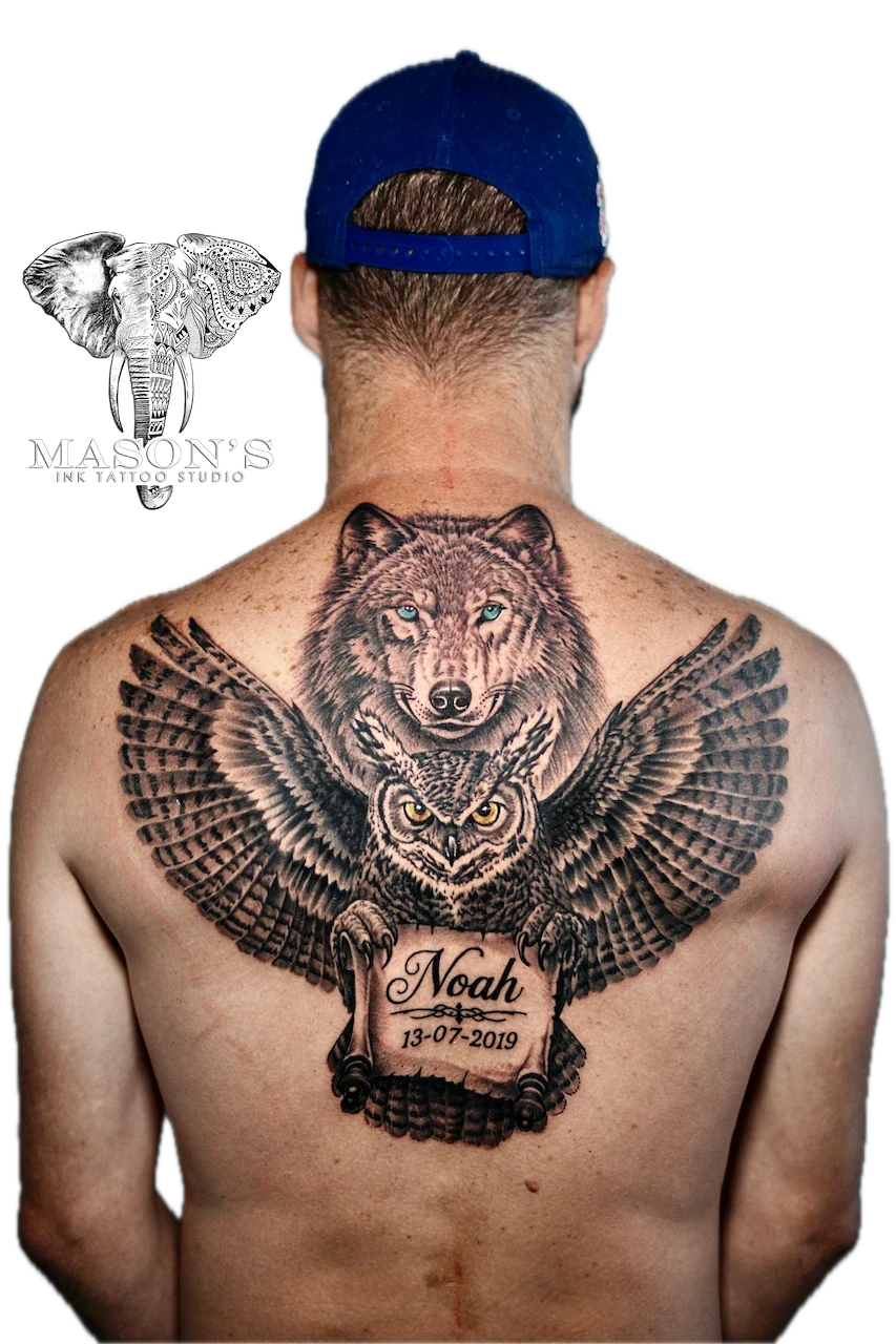 Black and Grey Tattoo Design: a large wolf and owl with wings and lettering on the back