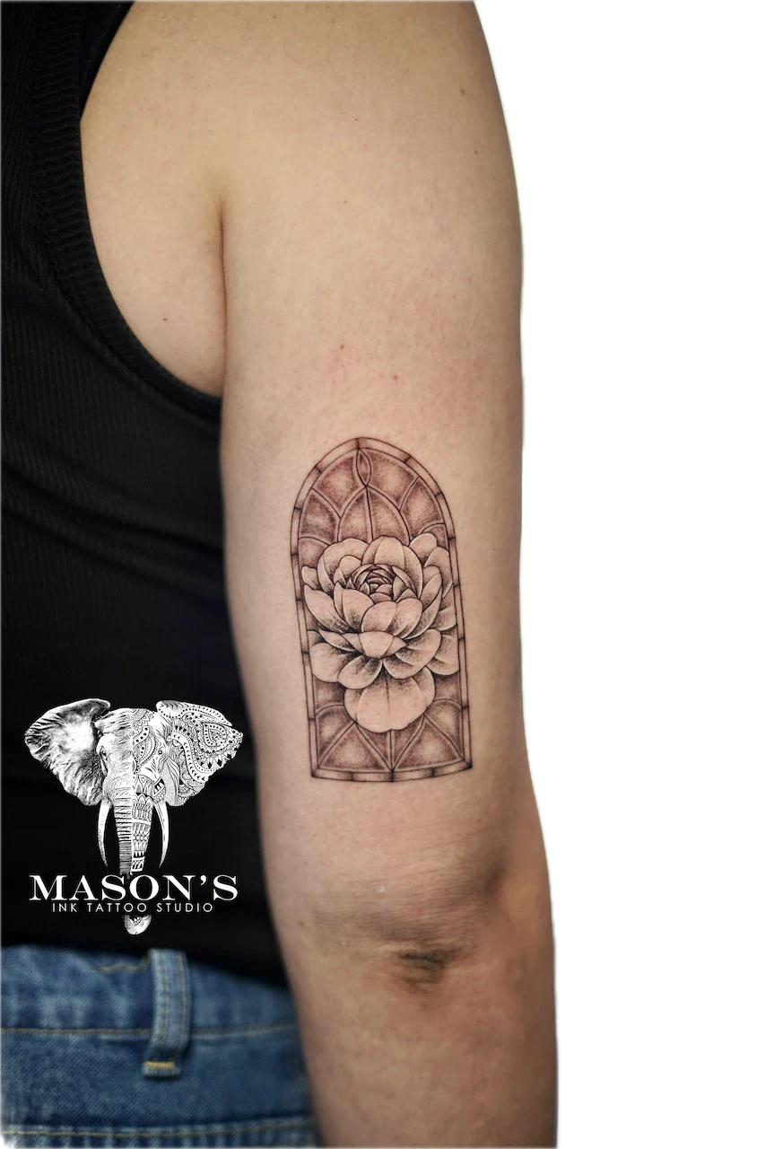 Black and Grey Floral Tattoo Design: a detailed flower in a geometric frame on the forearm