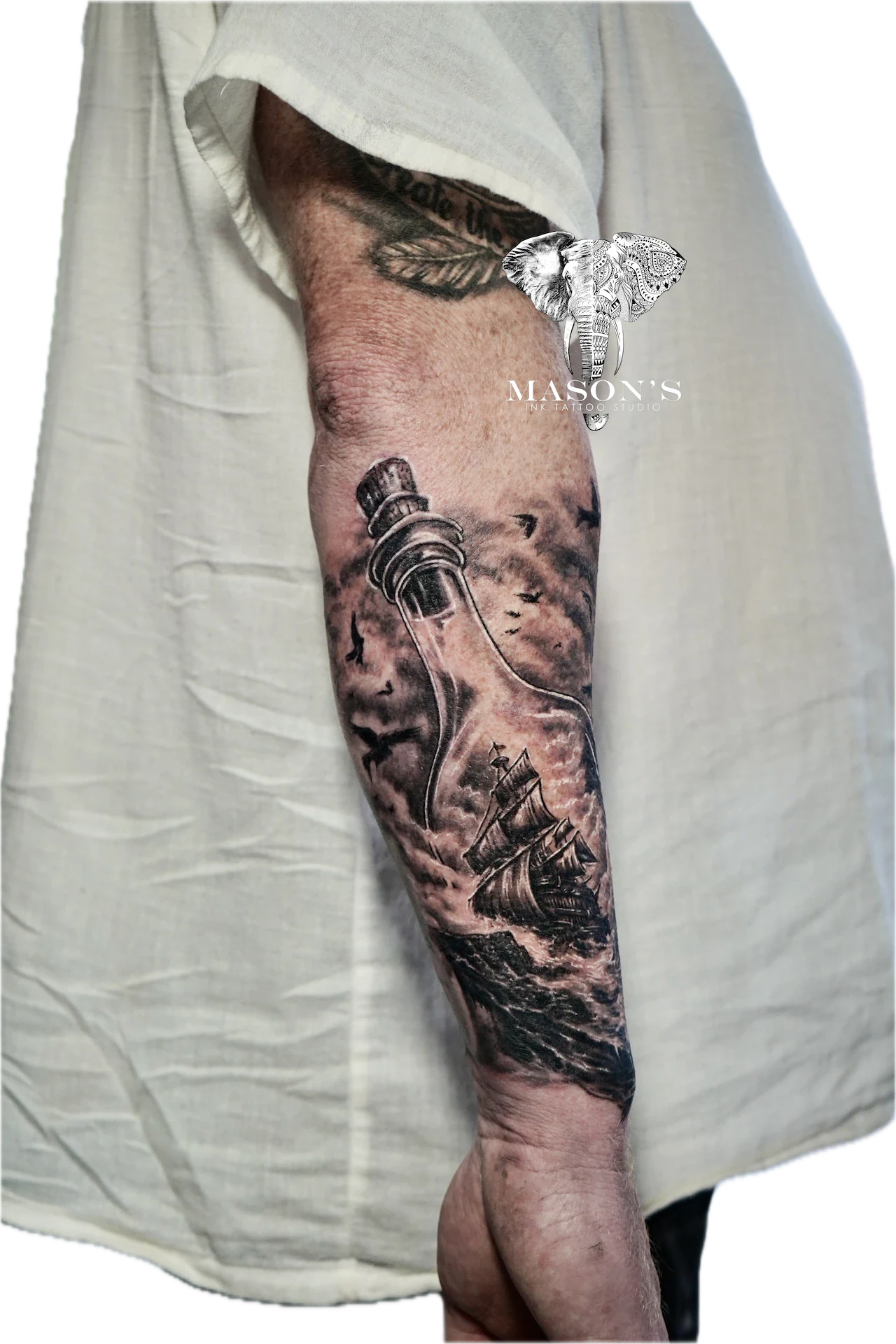 Black and Grey Realism Bottle Tattoo Design: a ship and diving helmet on a stormy ocean sleeve tattoo