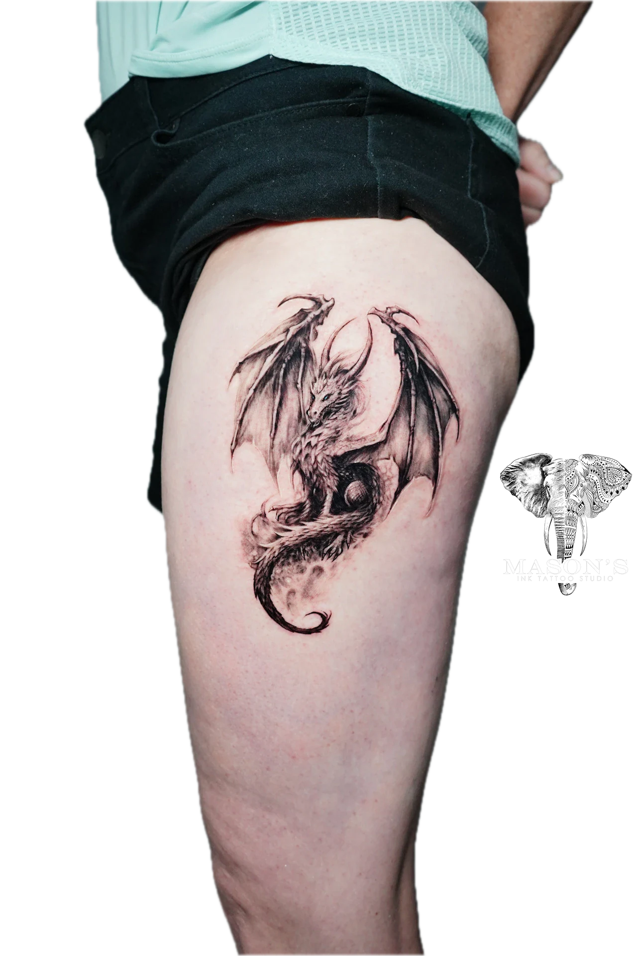 Black and Grey Realism Dragon Tattoo Design: a detailed dragon tattoo on the thigh