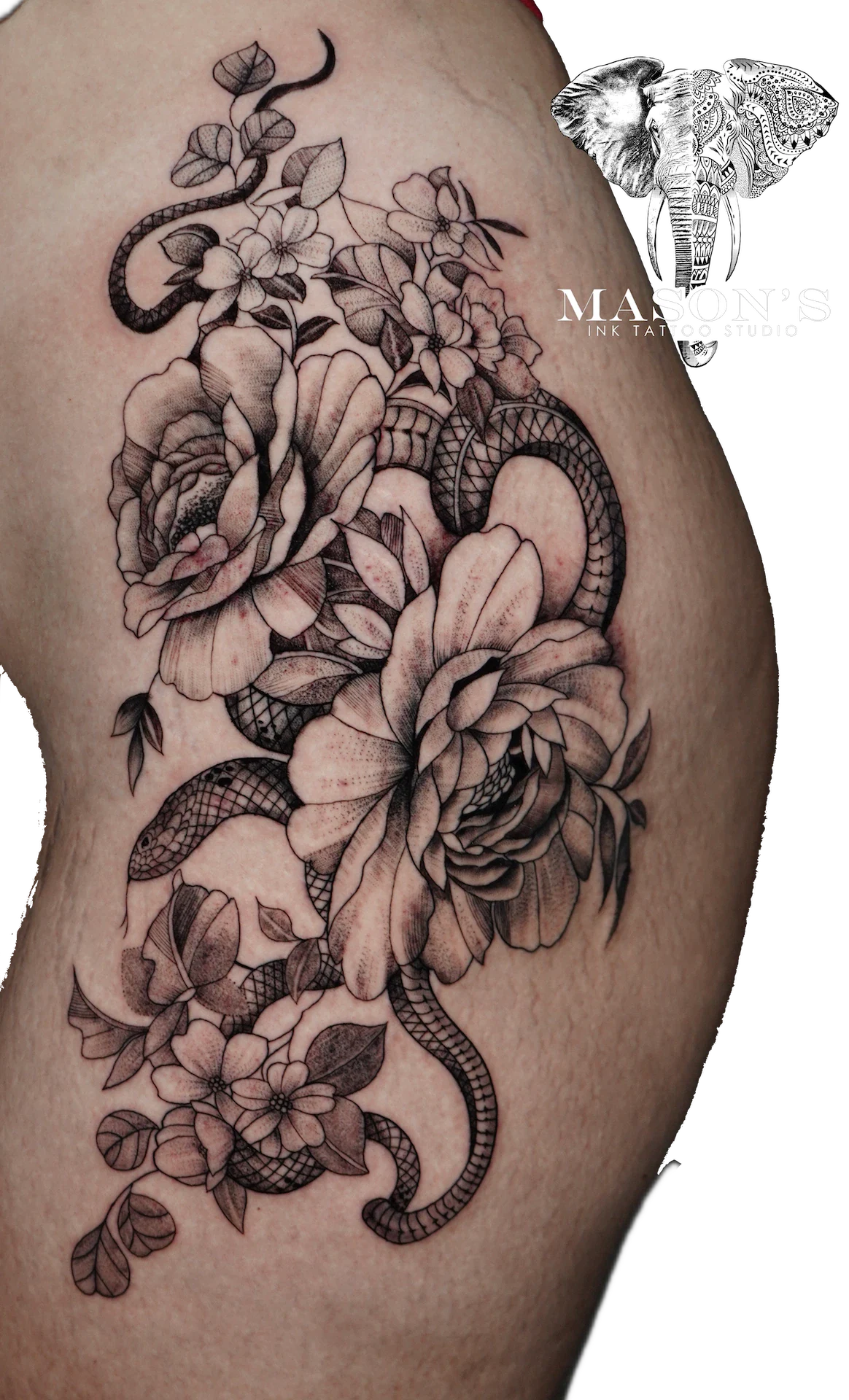 Black and Grey Floral Tattoo Design: a large snake entwined with flowers and leaves on a thigh