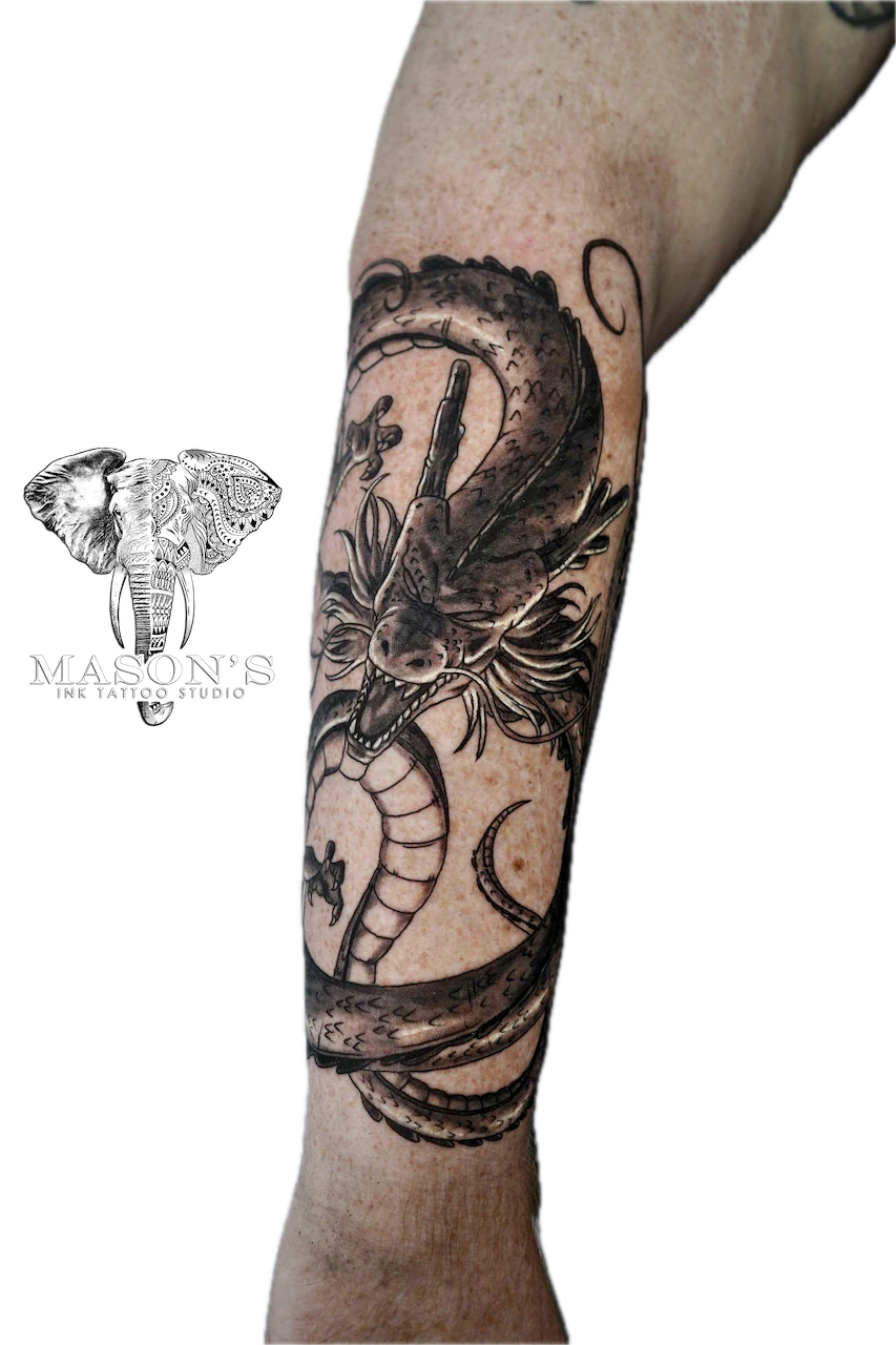 Black and Grey Dragon Tattoo Design: a large black and grey dragon and snake forearm tattoo with a moon and star