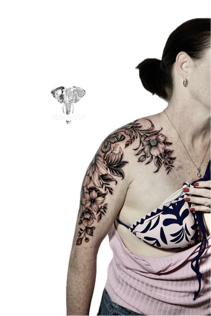 Black and Grey Flower Tattoo Design: a large floral tattoo with leaves and buds on the upper arm