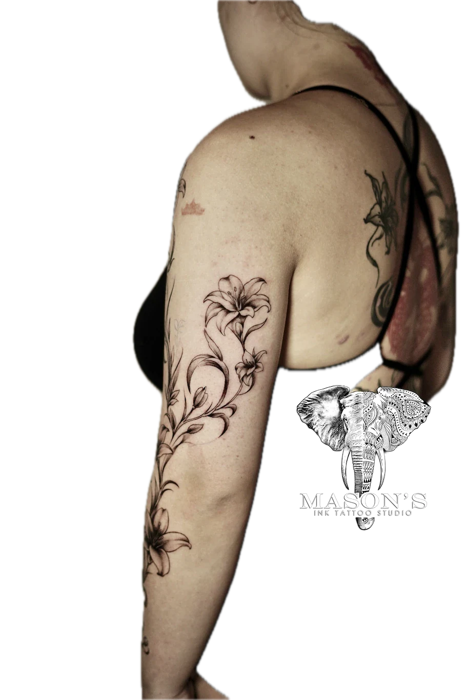 Black and Grey Flower Tattoo Design: a large black and grey floral tattoo with an elephant skull on the upper arm