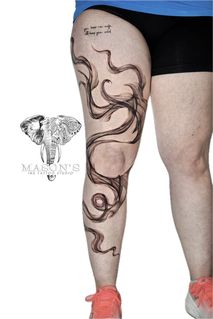Black and Grey Smoke Tattoo Design: a large black and grey thigh tattoo of flowing hair and swirls