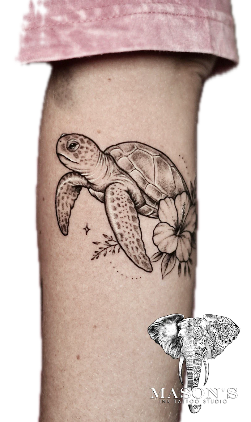 Black and Grey Turtle Tattoo Design: a turtle swimming with a flower on a forearm