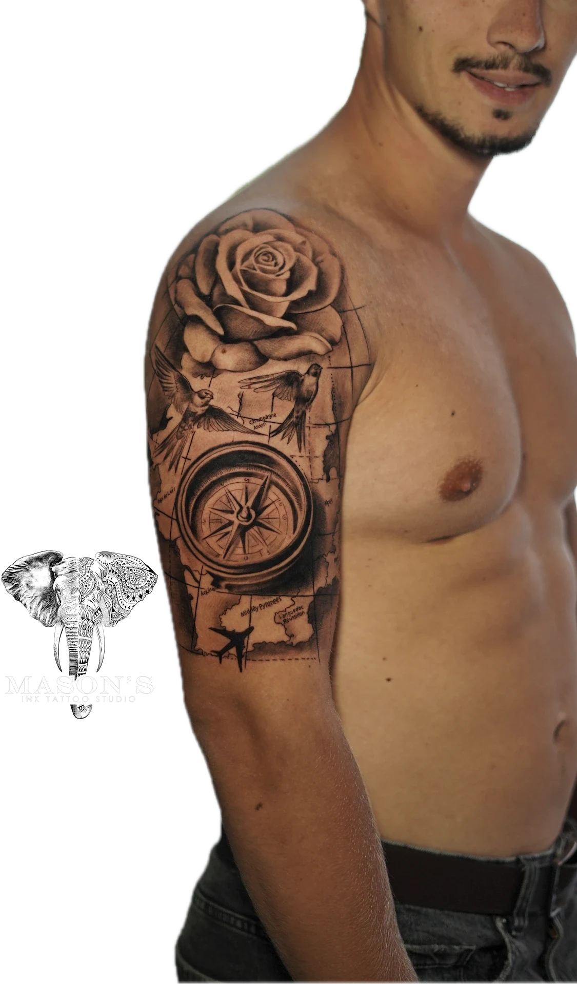 Black and Grey Floral Compass Tattoo Design: a detailed rose and compass tattoo with a map and bird on an upper arm