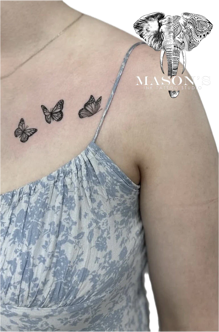Black and Grey Butterfly Tattoo Design: Three small butterflies on the shoulder with a strap design