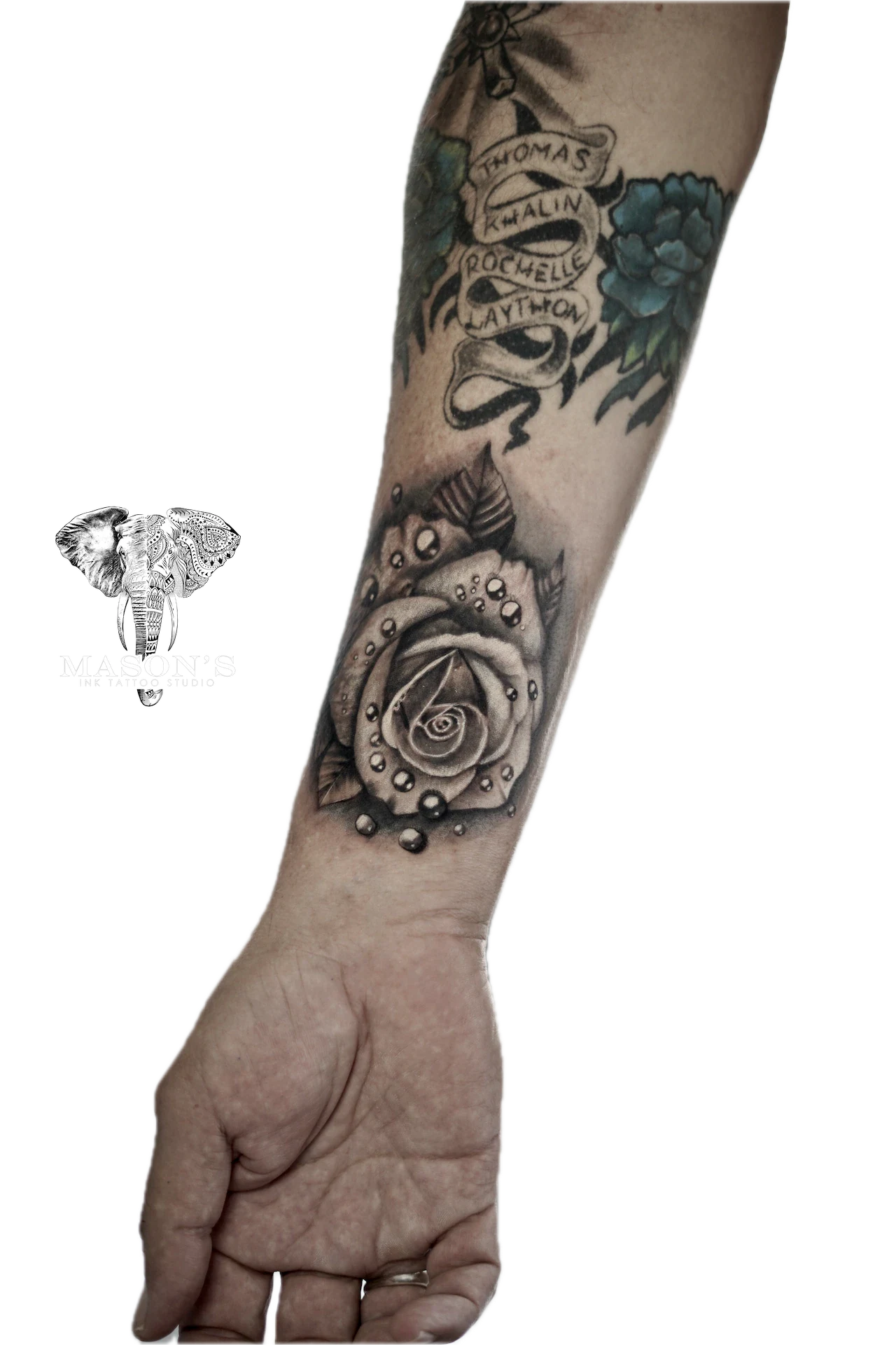 Black and Grey Floral Tattoo Design: a large forearm tattoo of a rose with lettering and floral elements
