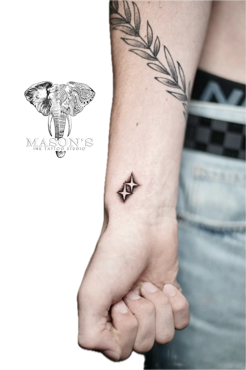 Blackwork Tattoo Design: Small minimalist star and laurel leaf tattoos on the forearm