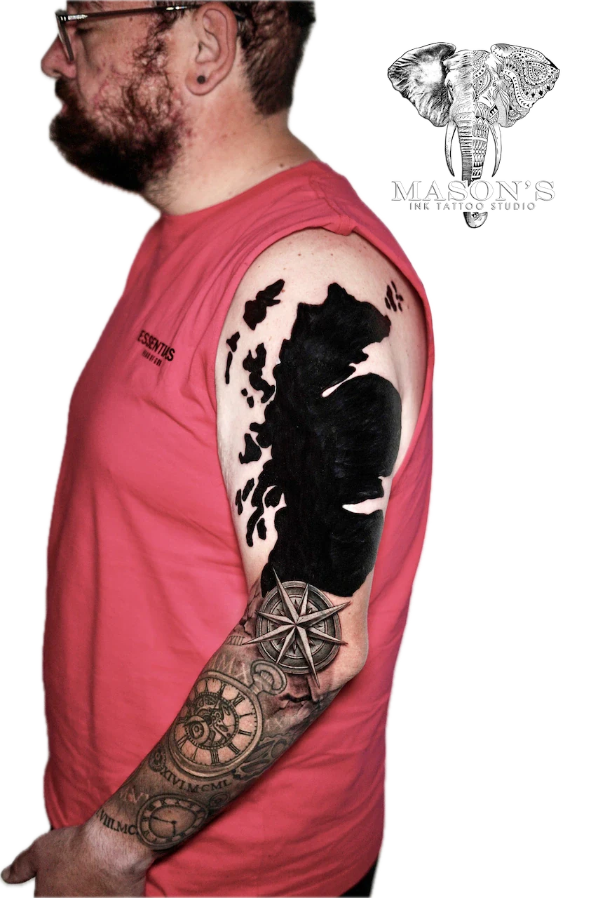 Black Work Tattoo Design: a large bear and compass tattoo on the upper arm