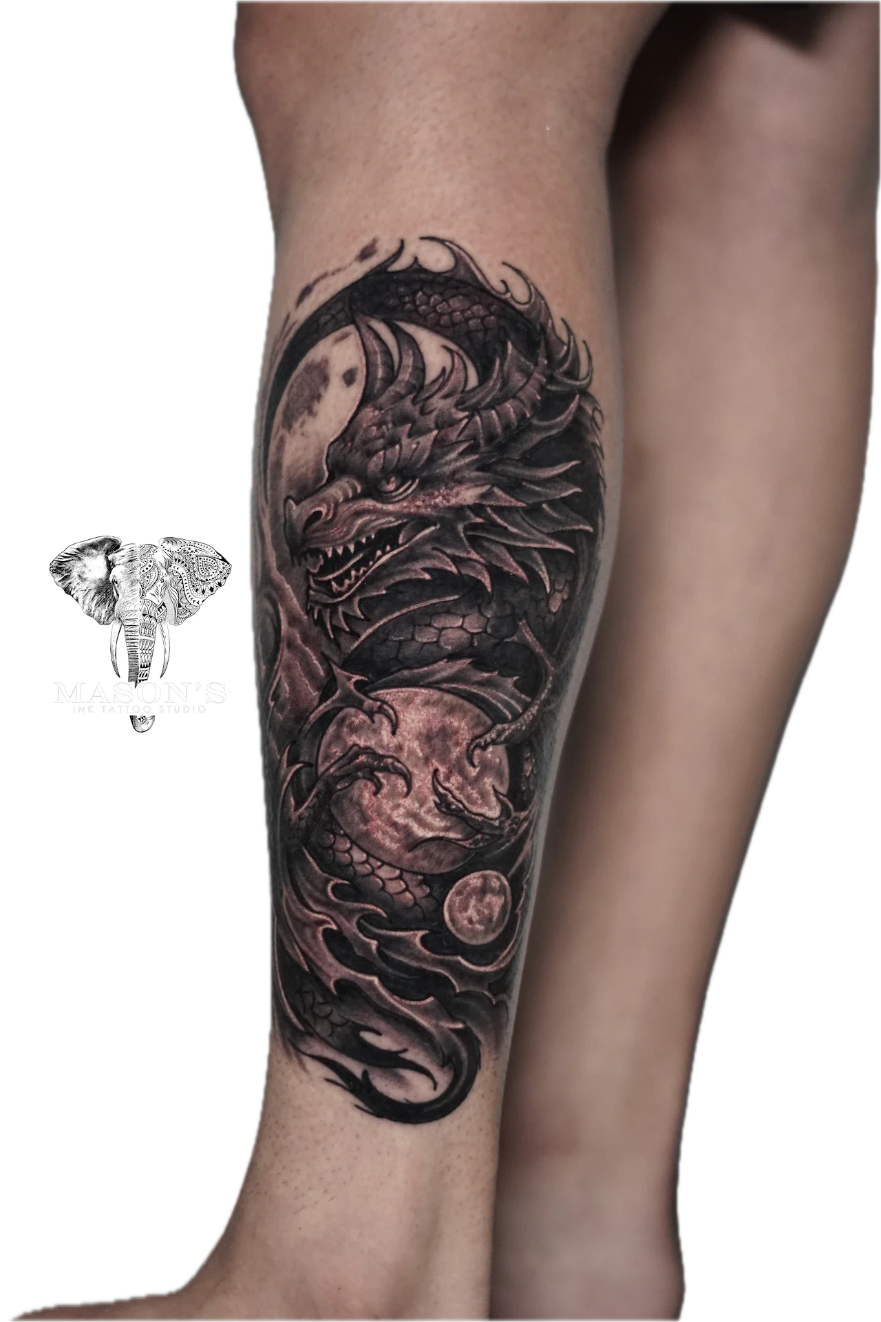 Japanese and Black Work Tattoo Design: a large black and grey dragon tattoo on a calf