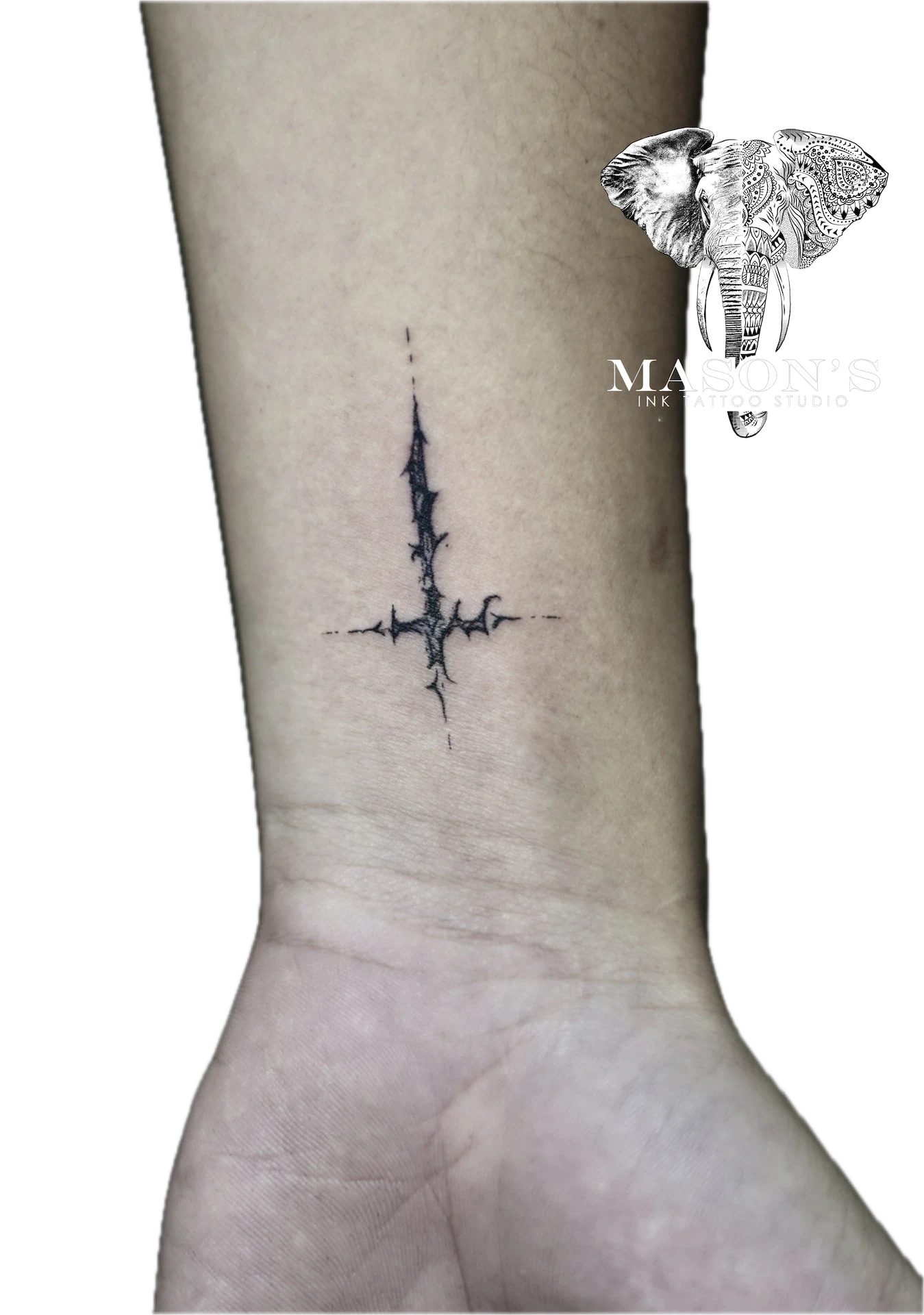 Black Work Reversed Cross Tattoo Design: a minimalist cross tattoo with thorny details on the forearm