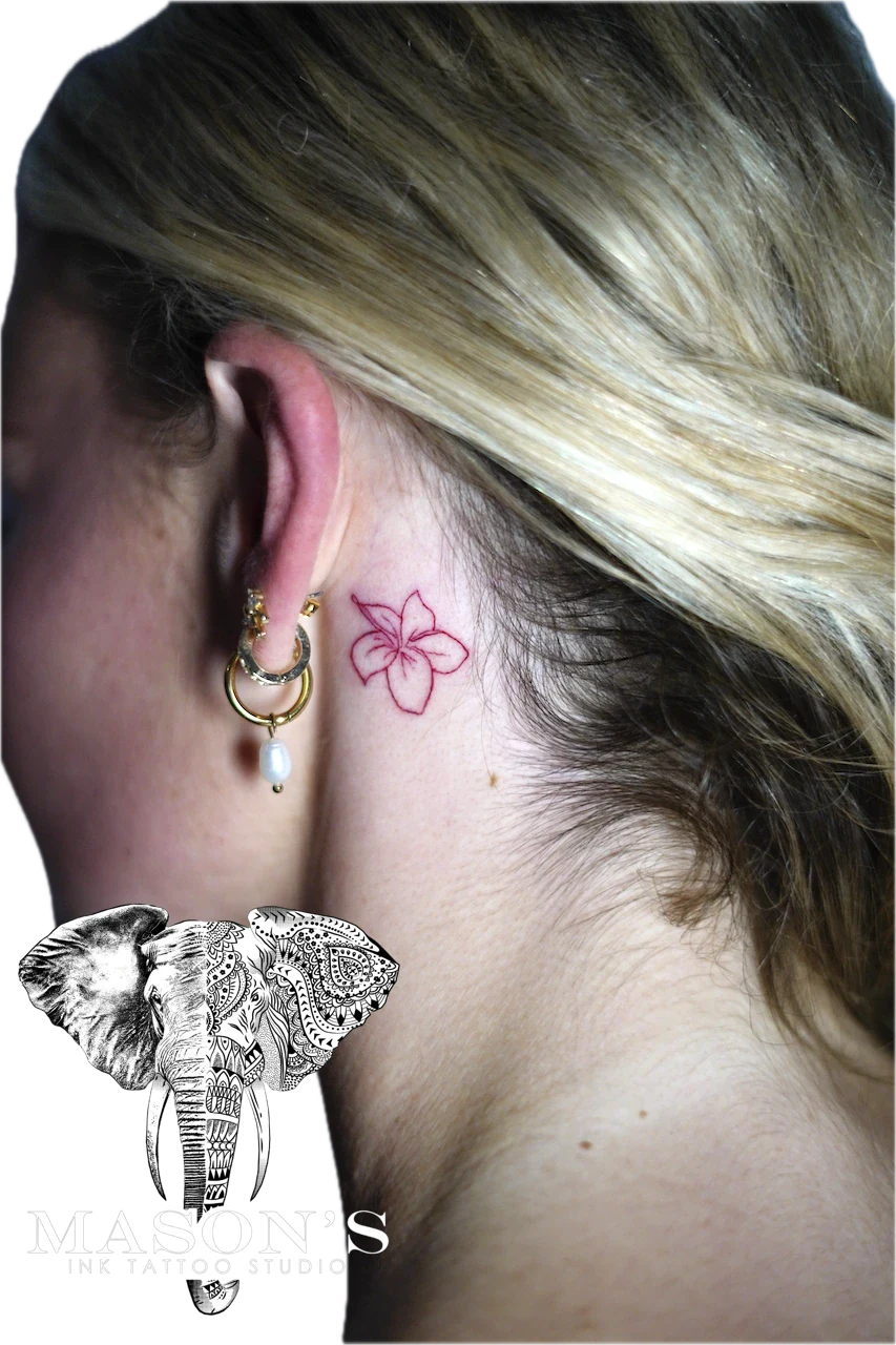 Fine Line Color Floral Tattoo Design: a small pink flower tattoo behind the ear