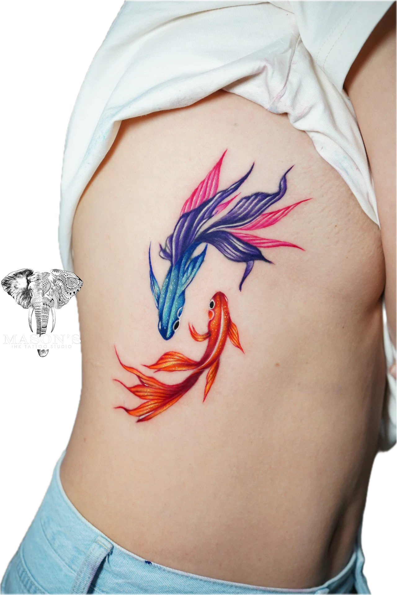 Color Tattoo Style Fish Design: Two colorful koi fish swimming on the ribs