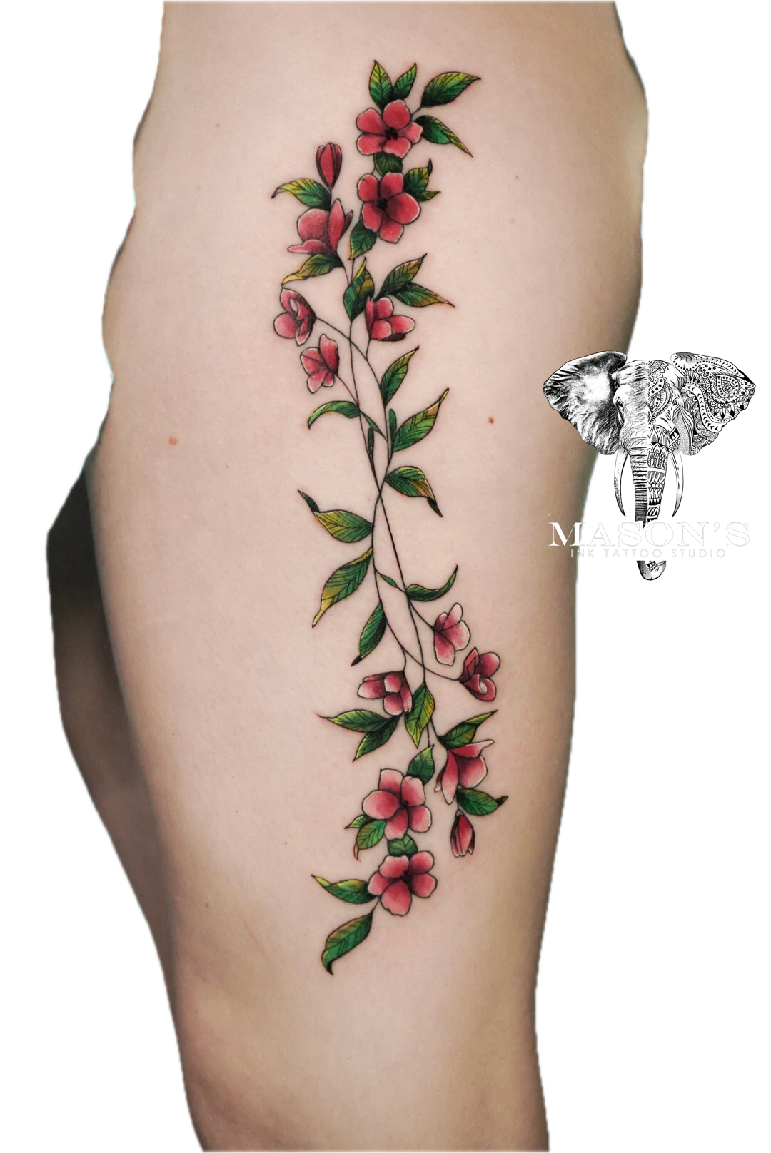 Colored Floral Tattoo Style Design: a vertical vine of pink flowers and green leaves on a thigh