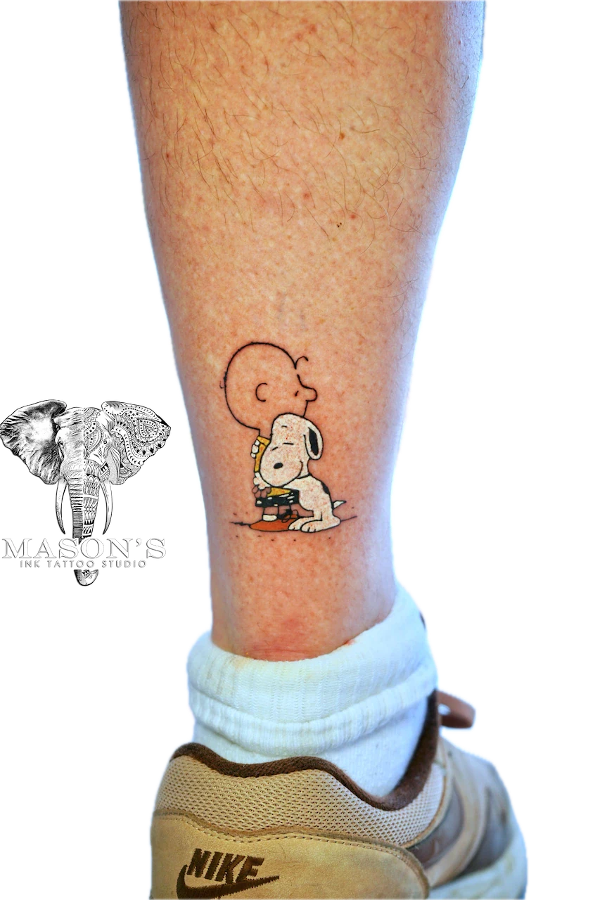 Color Tintin Tattoo Design: a small black and grey Snoopy tattoo on a calf