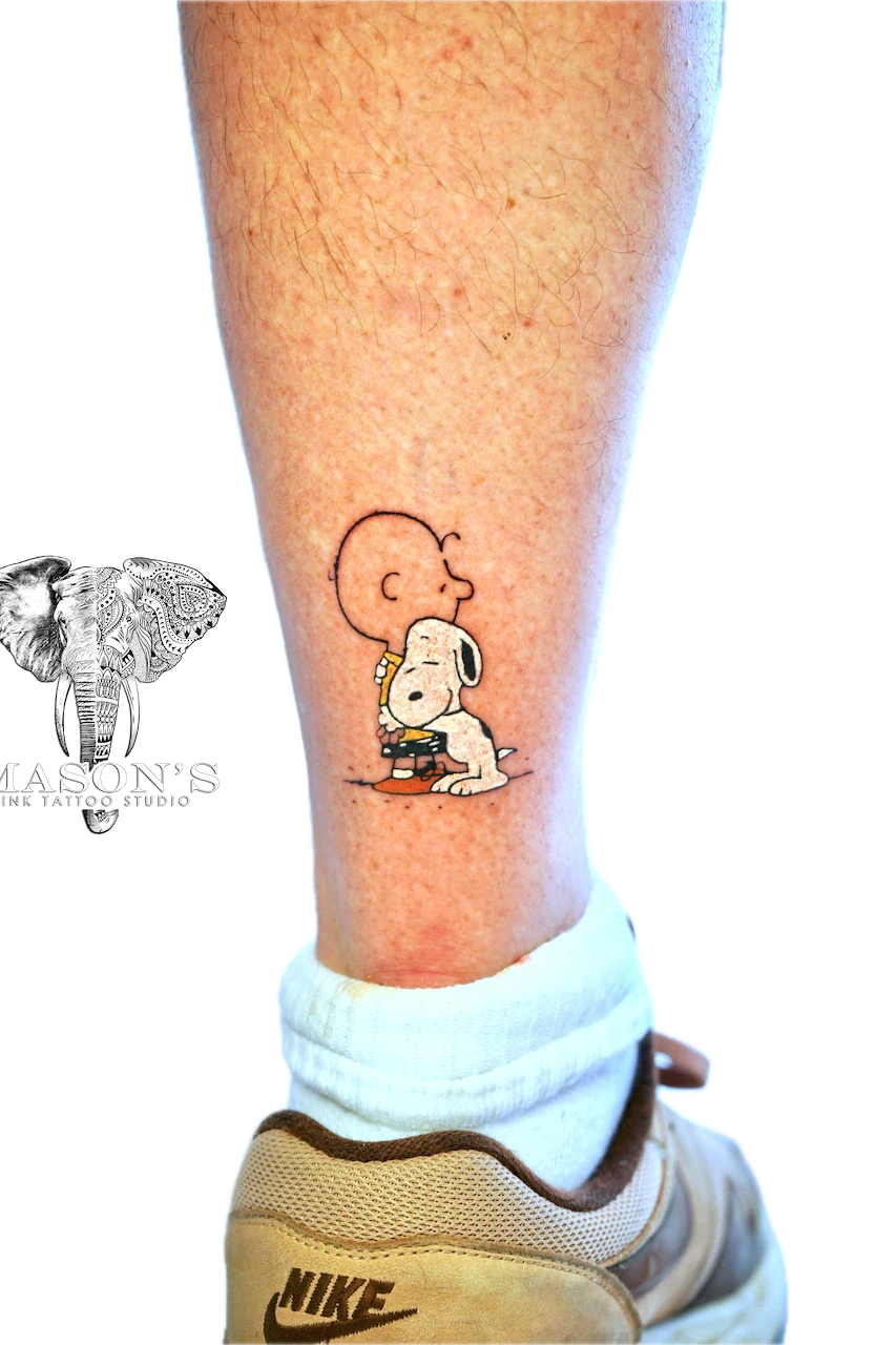 Color Tintin Tattoo Design: a small black and grey tattoo of Snoopy and Woodstock reading a book