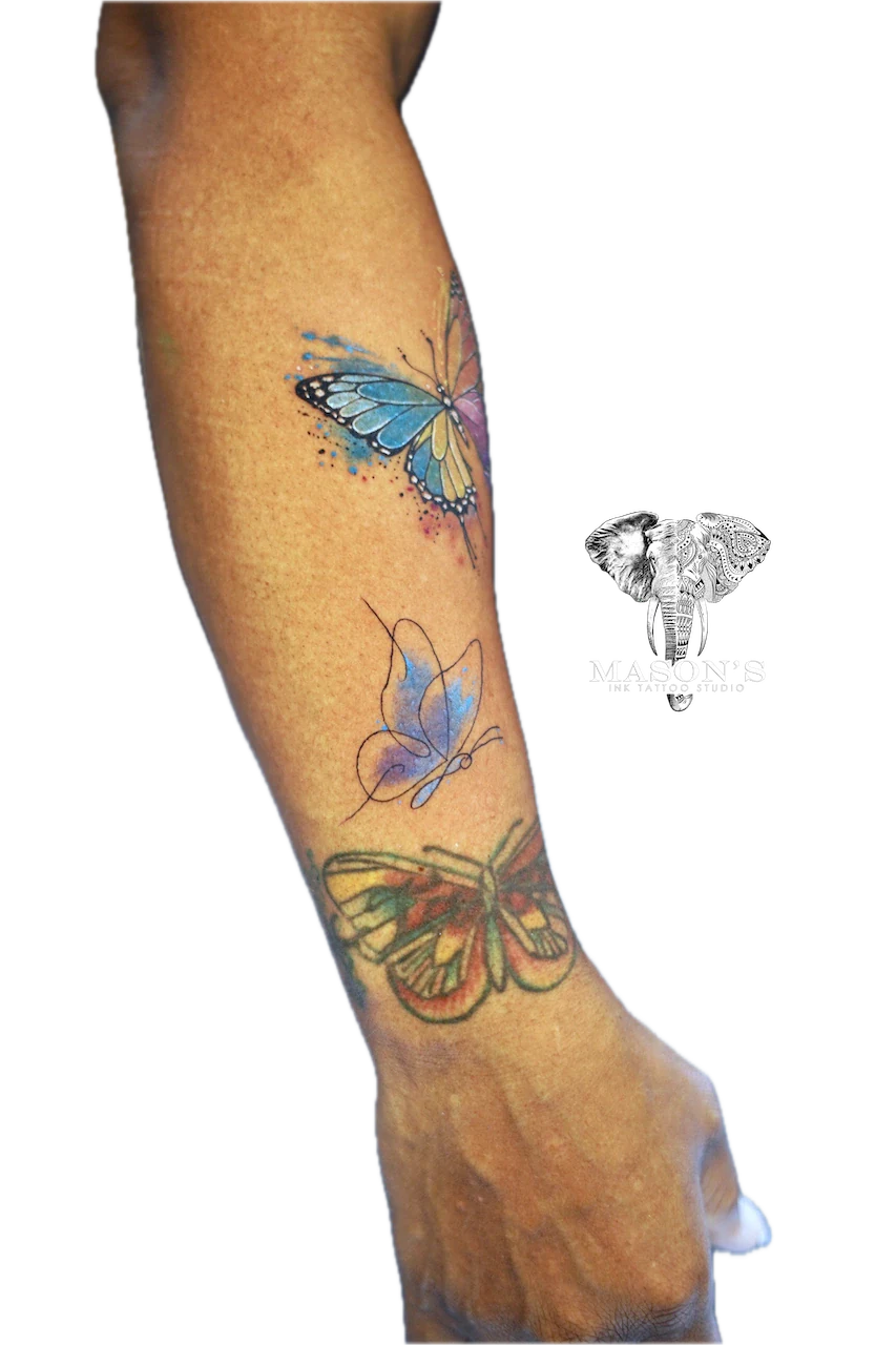 Watercolor Butterfly Tattoo by Mason’s Ink: Three colorful butterflies on the forearm