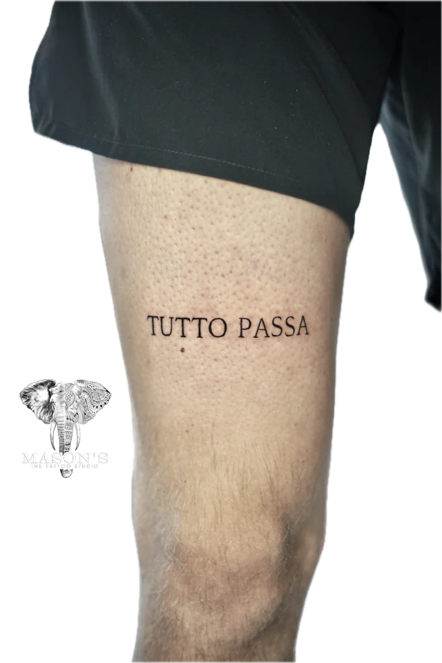 Fine line "Tutto Passa" script tattoo on thigh by Agus at Mason's Ink Tattoo Studio, Bali
