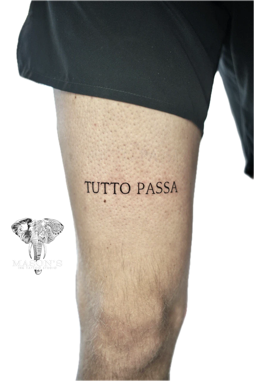 Fine line "Tutto Passa" script tattoo on thigh by Agus at Mason's Ink Tattoo Studio, Bali