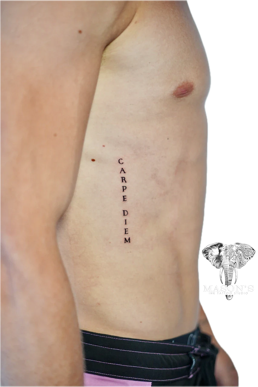 Fine Line Script Tattoo Design: Carpe Diem lettering on the ribs