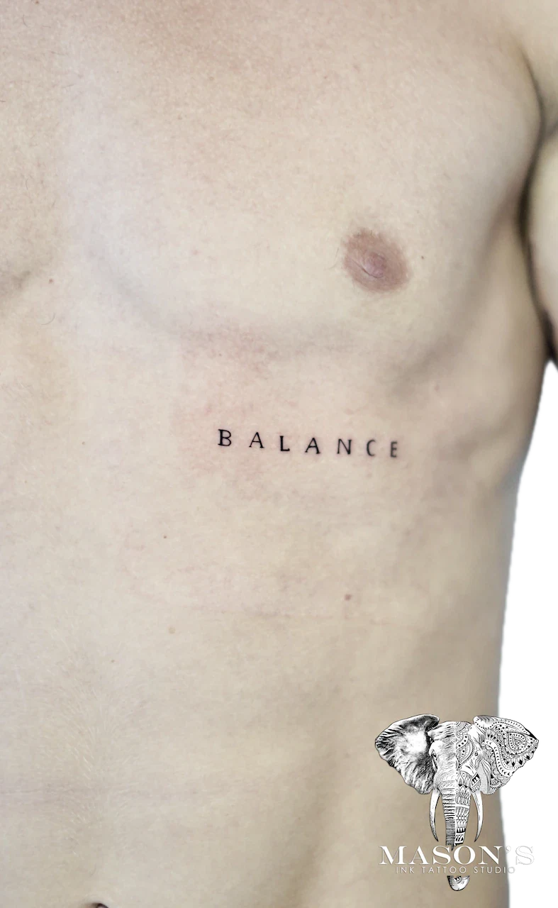 Fine Line Script Tattoo Design: Minimal black and grey lettering tattoo on the stomach