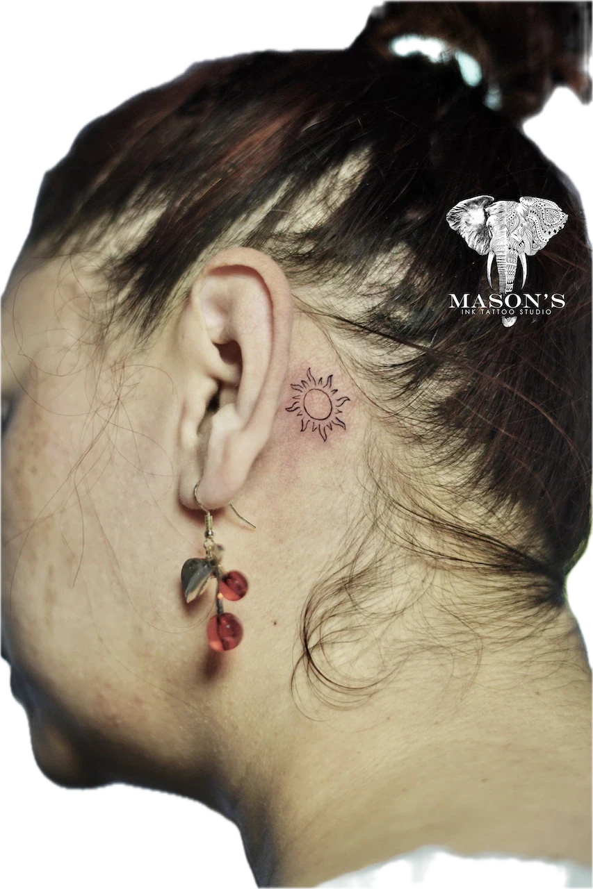 Fine Line Sun Tattoo Design: a minimal sun tattoo with rays behind the ear