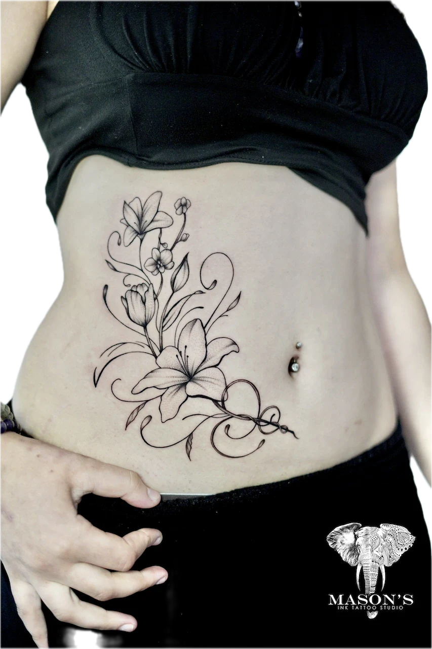 Fine Line Floral Tattoo Design: a detailed black and grey floral tattoo on the stomach