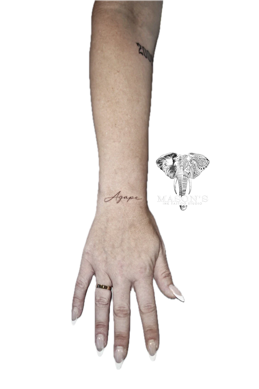 Fine Line Script Tattoo Design: Small forearm tattoo of the word 'Agape' in cursive