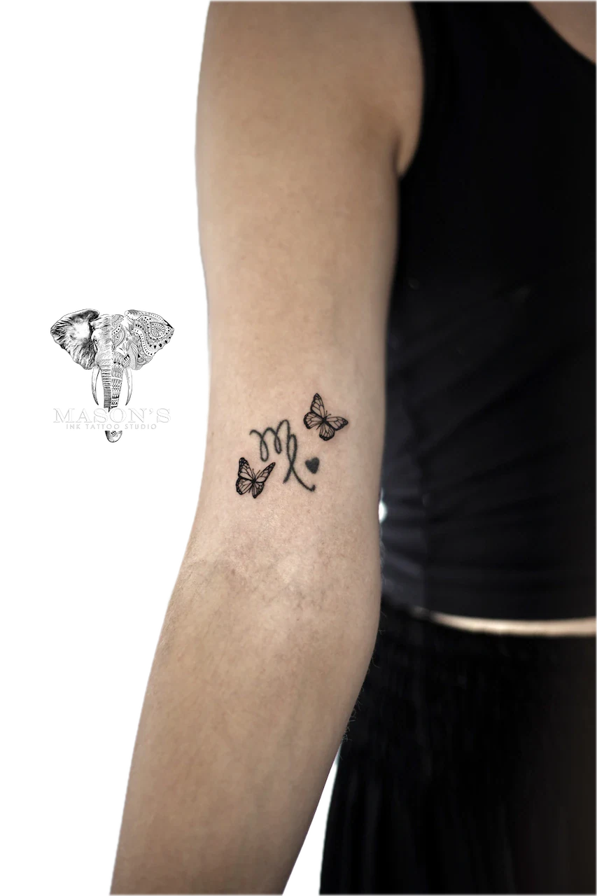 Fine Line Butterfly Tattoo Design: Minimalist forearm tattoo of butterflies and initials with a heart