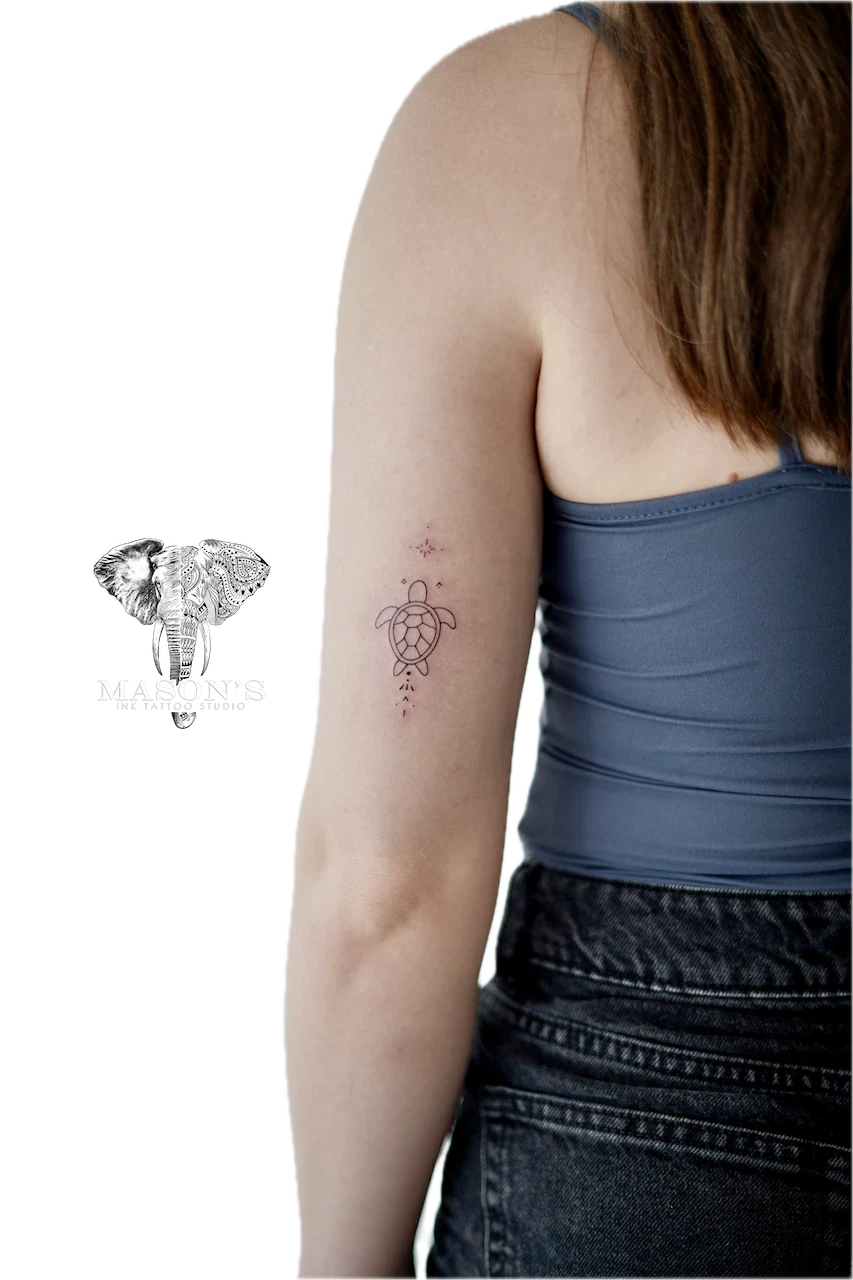 Fine Line Turtle Tattoo Design: a small turtle with stars and dots on the forearm
