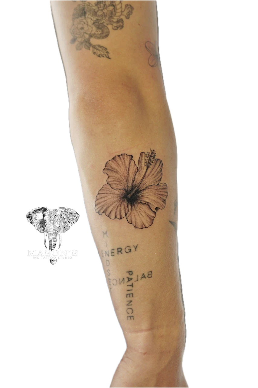 Fine Line Flower Tattoo Design: a hibiscus flower with lettering on the forearm