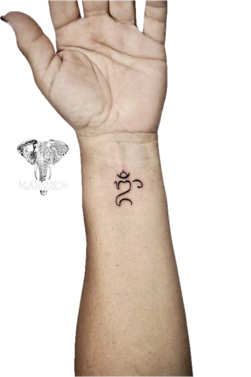 Fine Line Om Script Tattoo Design: Small spiritual symbol tattoo on the forearm
