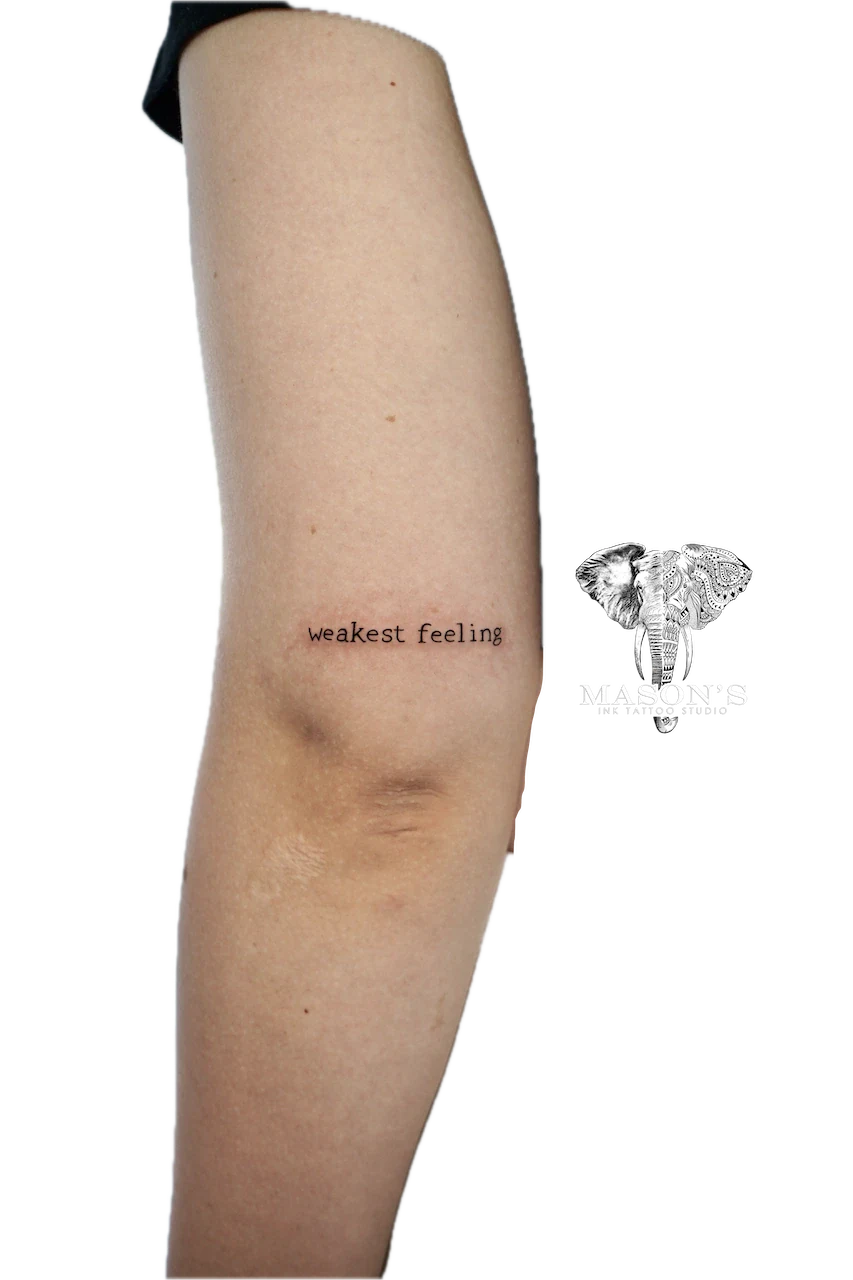 Fine Line Script Tattoo: Small black and grey lettering on the thigh