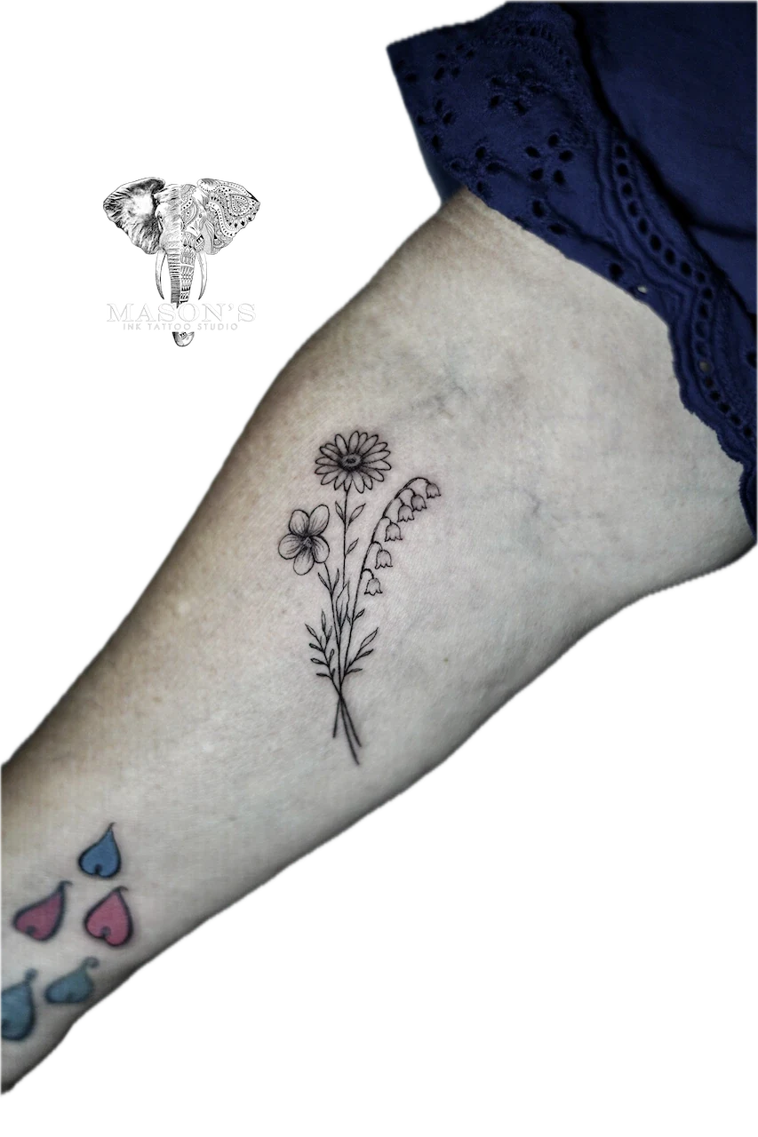 Fine Line Flower Tattoo: a small floral tattoo with colorful teardrops on the calf
