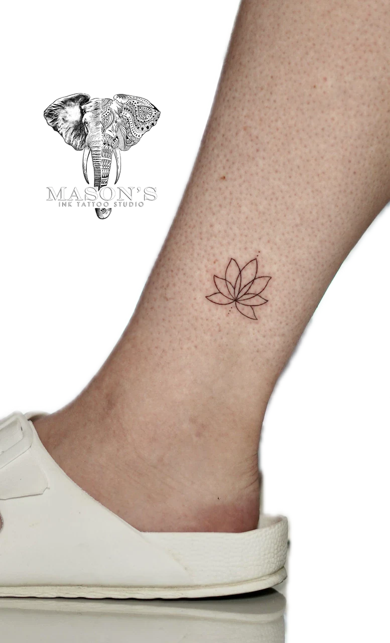 Fine Line Flower Tattoo Design: a minimal lotus flower tattoo on the ankle
