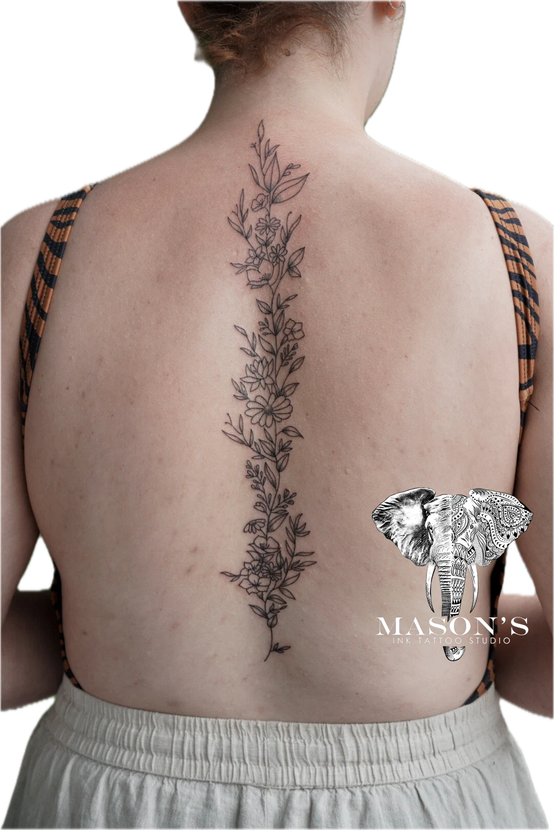 Floral Fineline Tattoo Design: a large floral vine with an elephant ring on the back