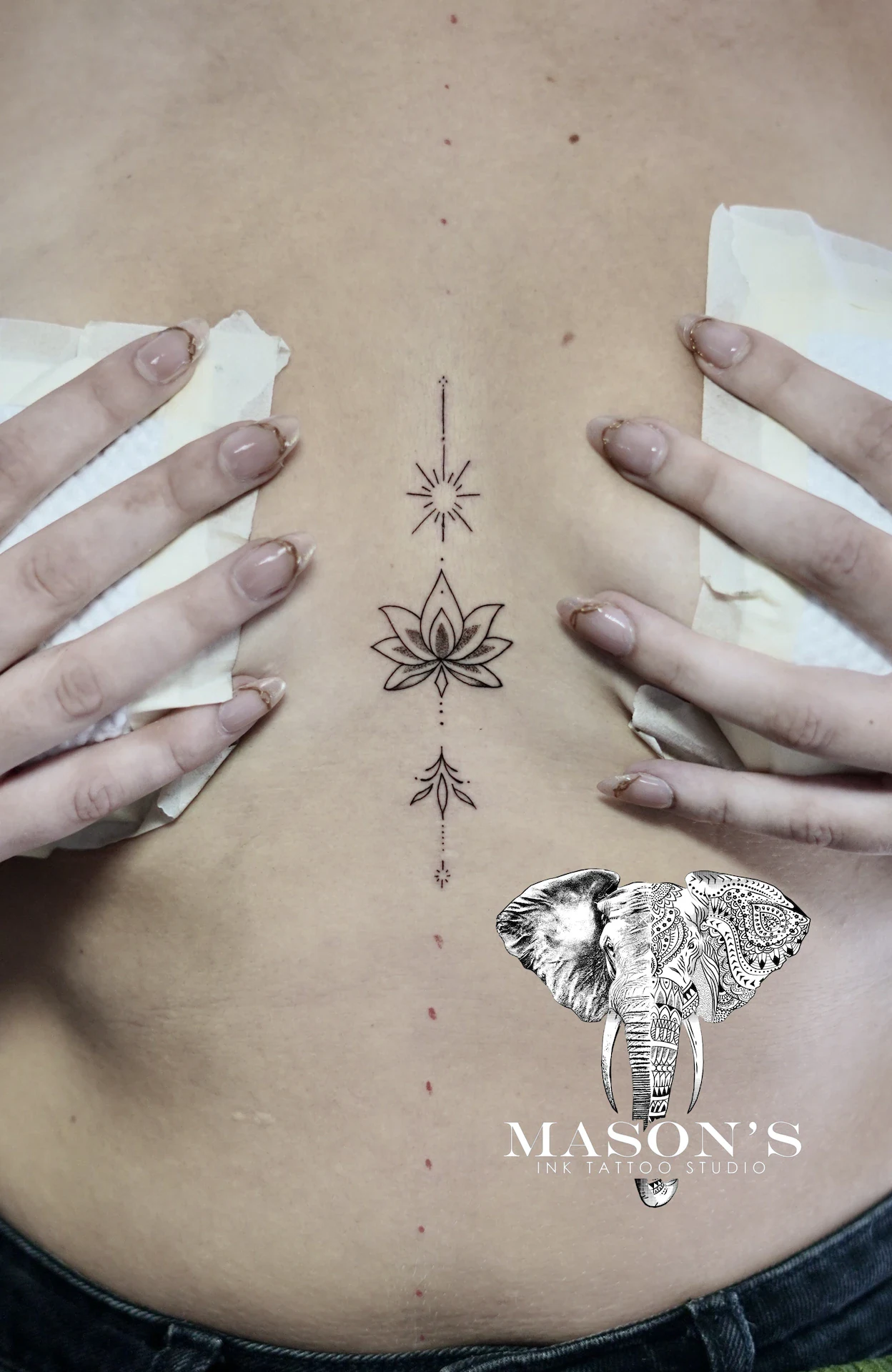 Fine Line Lotus Tattoo Design: a minimal lotus and star tattoo on the stomach