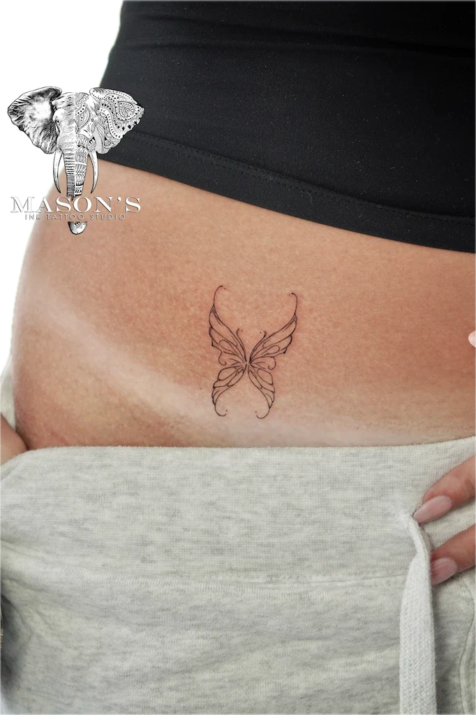 Fine Line Butterfly Tattoo Design: a minimal butterfly tattoo on the stomach