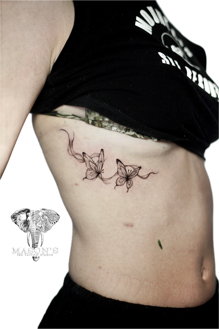 Fine Line Butterfly Tattoo Design: Two delicate flowers with vines on the stomach