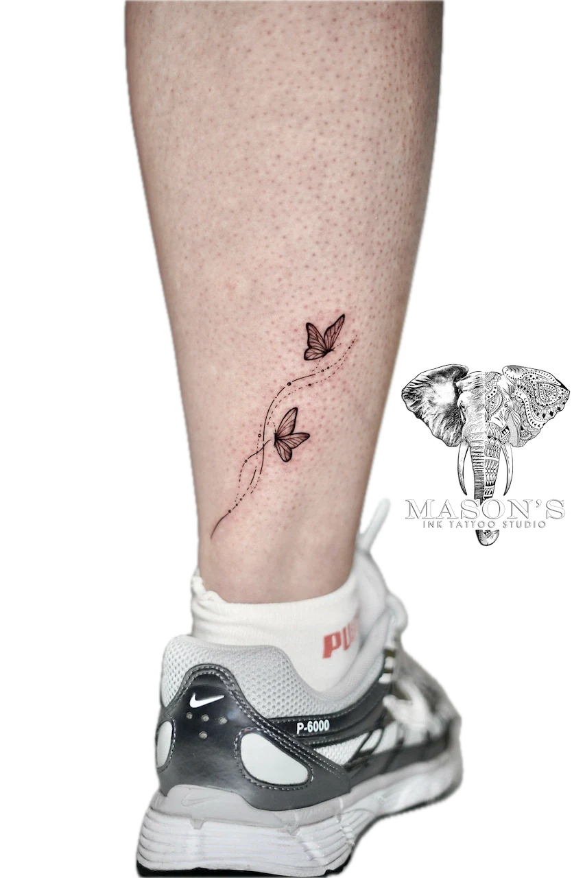 Fine Line Butterfly Tattoo Design: Two butterflies on a vine with dotted lines on a calf